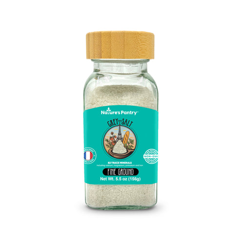 Glass jar of Nature's Pantry coarse salt with a wooden lid on a white background