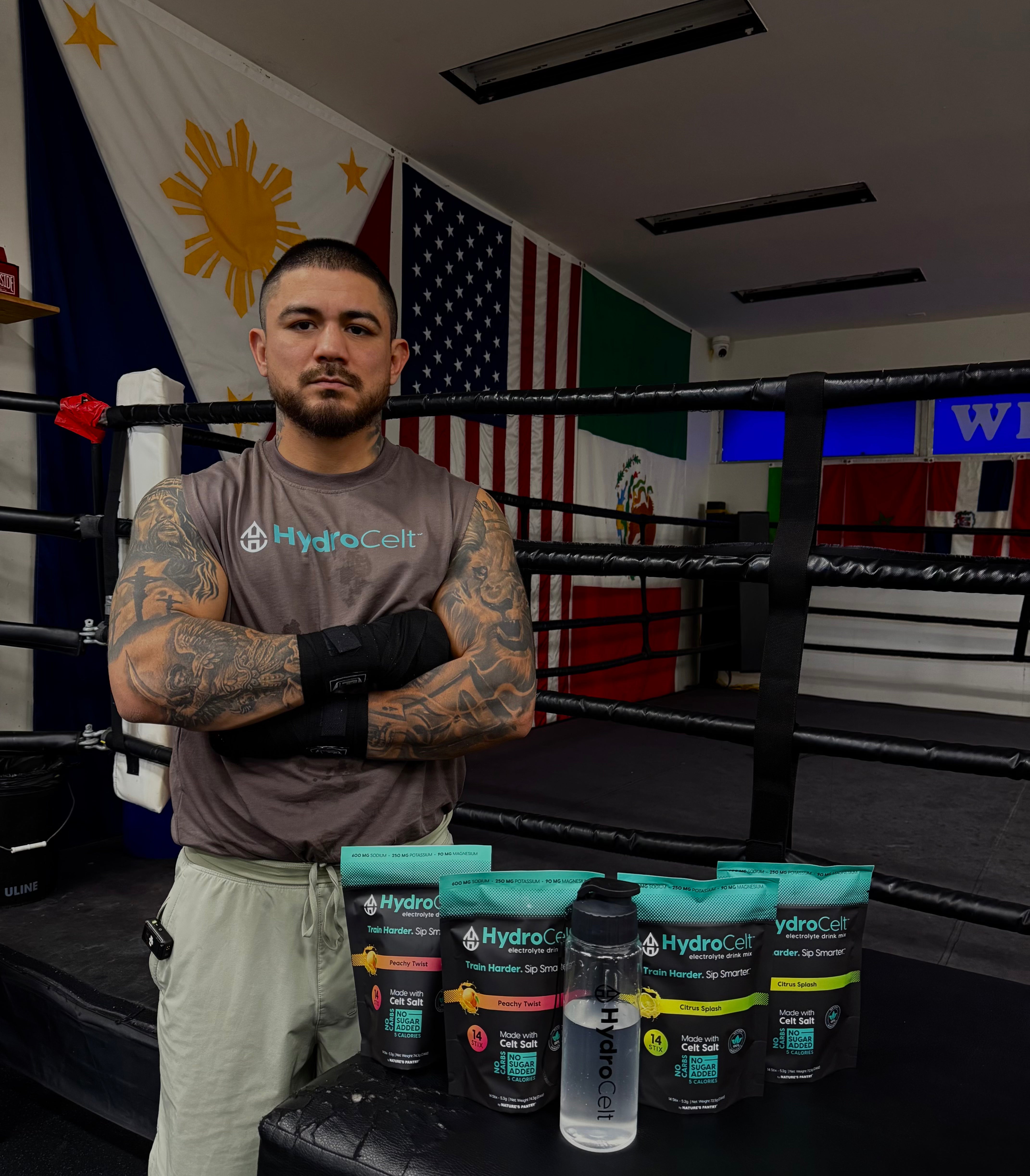 Man standing in a boxing ring with Hydrocell products displayed in front